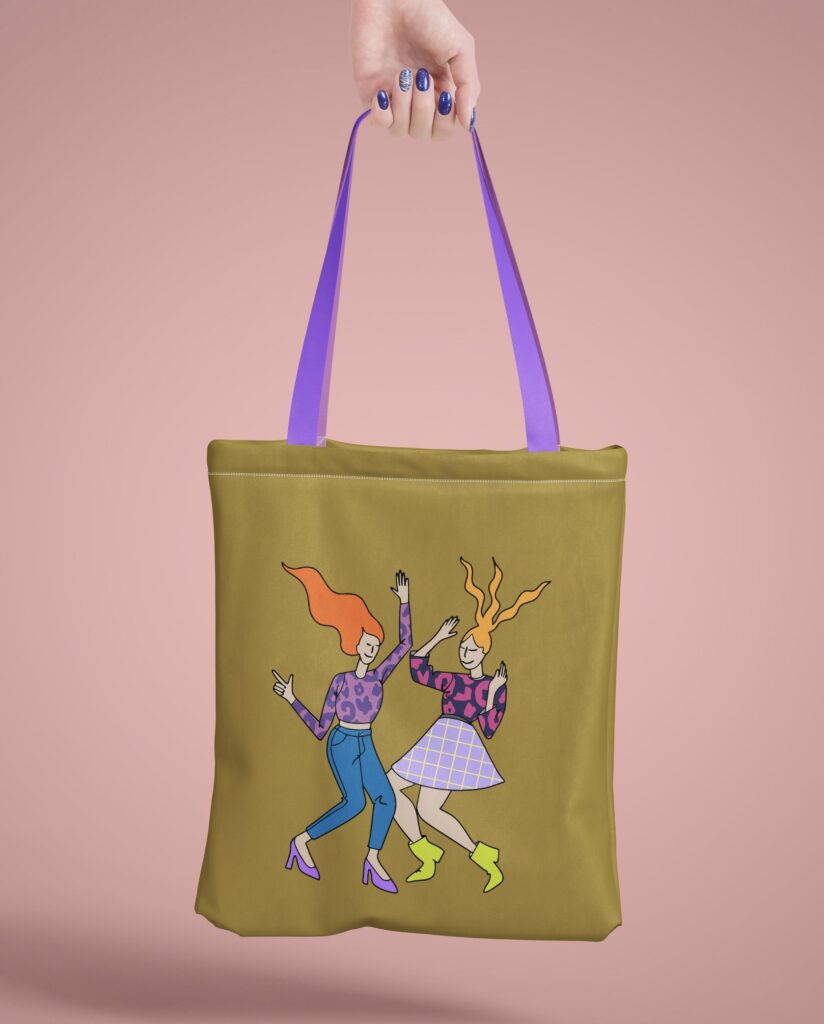 Eine olivgrüne Stofftasche mit dem Bügelbild TANZEN-SET, das zwei tanzende Frauen mit bunten Outfits auf einem pastellrosa Hintergrund zeigt.