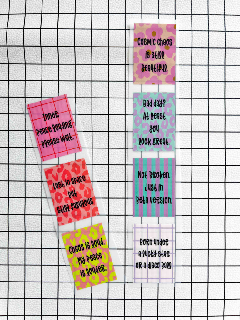 Sechs bunte Sticker mit motivierenden Sprüchen auf weißem Gitterhintergrund, gestaltet von Anke mit verschiedenen Mustern und verspielter Typografie.